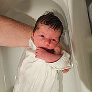 Ambre participe au concours pour gagner de l'argent avec cette photo : newborn, baby, bathtub, water, adult_arm, white_cloth, infant, skin, wet_hair, bath, person, supporting_hand, young_child, indoors, closeup, tub, human, child, resting, soothing