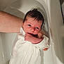 newborn, baby, bathtub, water, adult_arm, white_cloth, infant, skin, wet_hair, bath, person, supporting_hand, young_child, indoors, closeup, tub, human, child, resting, soothing