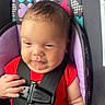 Maelani is registered to the contest to win money with this photo: baby, car_seat, child, infant, red_shirt, butterfly_pattern, seatbelt, face, hand, expression, cute, indoors, closeup, safety_harness, person, young_child, head, apparel, seat, child_safety