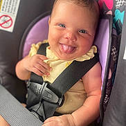Maelani is registered to the contest to win money with this photo: baby, child, car_seat, smiling, tongue_out, happy, infant, seatbelt, safety, cute, portrait, closeup, clothing, yellow, hand, face, seat, colorful, funny, cheerful