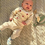 Marceau participe au concours pour gagner de l'argent avec cette photo : baby, infant, smiling, knit_blanket, cozy_clothing, heart_pattern, indoor, soft_light, milestone, decorative_toy, footwear, cute, lying_down, happy, portrait, child, warm_tones, texture, baby_girl, baby_boy