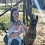 Rex a rejoint le concours — aidez-le/la à gagner de superbes lots ! woman, baby, dog, outdoor, sunlight, gravel, fence, grass, nature, crouching, holding, pet, animal, casual_clothing, daytime, portrait, mammal, companion, human, rural