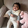 Arlo is registered to the contest to win money with this photo: baby, child, smiling, striped_clothing, bib, pink_toy, stuffed_animal, armchair, cozy, happy, indoor, portrait, cute, infant, seated, plush, soft_texture, person, looking_up, comfortable
