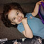 toddler, child, smiling, curly_hair, tablet, blue_shirt, couch, floral_blanket, comb, happy, indoor, person, playful, relaxed, cute, young_child, furniture, hand, portrait, cozy