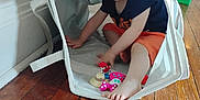 Ophelia joined the competition — help win amazing prizes! barefoot, basket, child, clothing, curious, cute, face, floor, home, indoor, person, play, shirt, shorts, sitting, smile, toddler, toy, wooden_floor, young