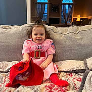 Ophelia joined the competition — help win amazing prizes! blanket, child, couch, cozy, curly_hair, curtains, furniture, happy, home_interior, indoor, living_room, person, pink_dress, red_belt, red_hat, red_socks, seated, smiling, toddler, window