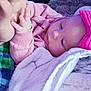 baby, infant, pink_clothing, headband, blanket, hand, adult_hand, sleeping, cozy, soft_texture, closeup, cute, tender, resting, child, person, warmth, indoor, comfort, bonding