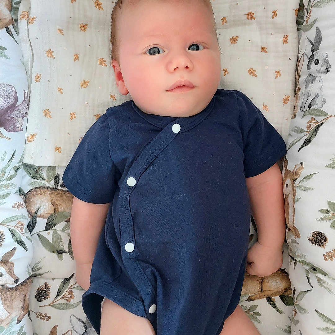 Jules participe au concours pour gagner de l'argent avec cette photo : animal_print, baby, blanket, blue_clothing, child, cute, deer, face, feet, indoors, infant, legs, lying_down, newborn, onesie, peaceful, portrait, rabbit, resting, soft_bedding