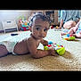 Meilani is registered to the contest to win money with this photo: baby, child, diaper, toy, carpet, indoor, playtime, curly_hair, person, floor, colorful, controller, kids, family, candid, cute, infant, young_child, relaxed, home
