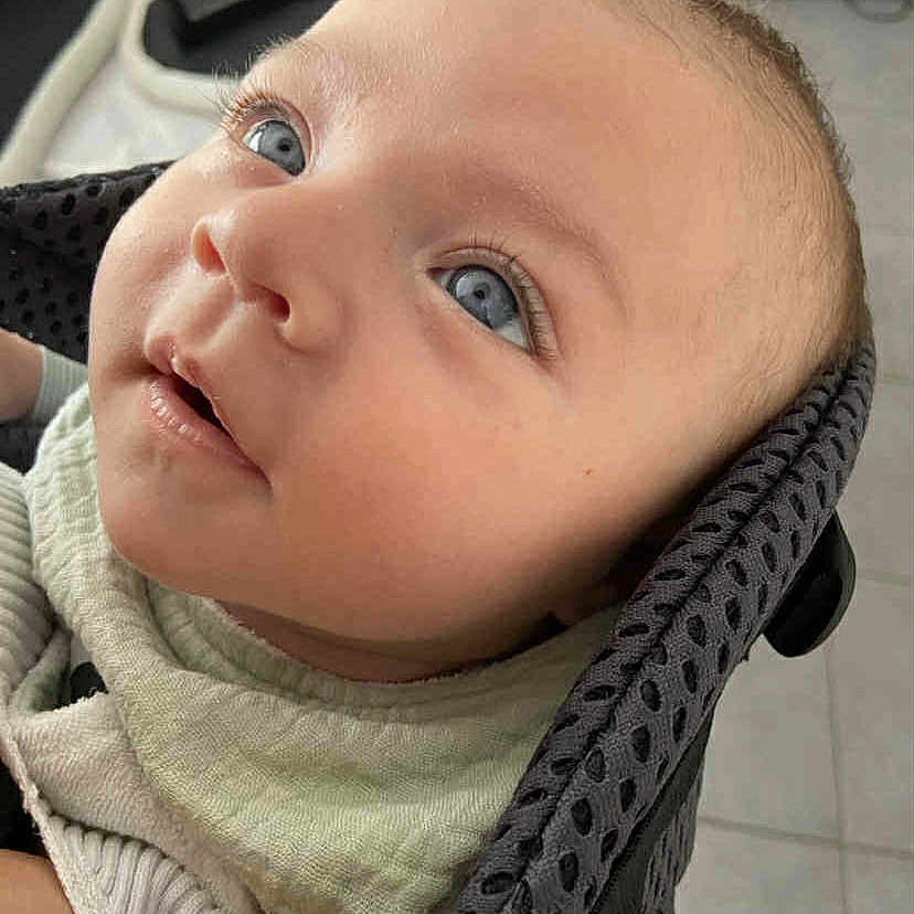 Tiago a rejoint le concours — aidez-le/la à gagner de superbes lots ! baby, blue_eyes, child, close_up, comfort, curious, cute, expression, face, gazing_upwards, head, human, indoors, infant, padded_seat, person, portrait, skin, soft_clothing, young