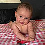 arms, baby, bed, blanket, checkered_pattern, child, cute, expression, eyes, face, happy, head, indoors, infant, lying_down, person, skin, smiling, tongue, young