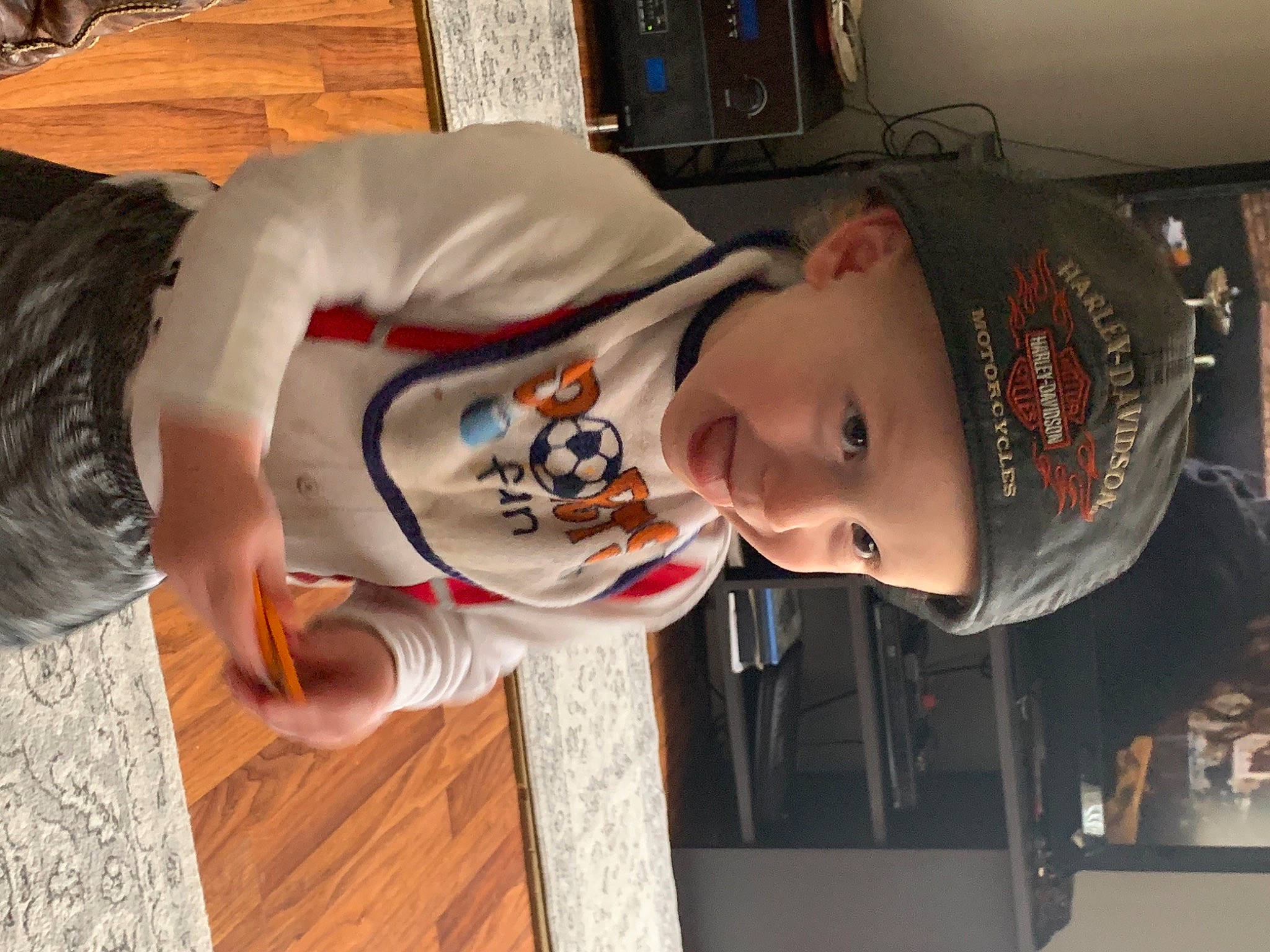 Aden joined the competition — help win amazing prizes! cap, child, flooring, fun, happy, hardwood, headwear, pattern, person, room, sleeve, smile, t_shirt, toddler, wood, wood_stain