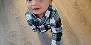 Zaiden is registered to the contest to win money with this photo: toddler, child, hand, floor, plaid_shirt, indoor, person, looking_up, hair, holding_hand, curious, cute, skin, adult_hand, wooden_floor, young_child, casual_clothing, portrait, baby, human
