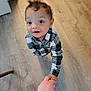 toddler, child, hand, floor, plaid_shirt, indoor, person, looking_up, hair, holding_hand, curious, cute, skin, adult_hand, wooden_floor, young_child, casual_clothing, portrait, baby, human