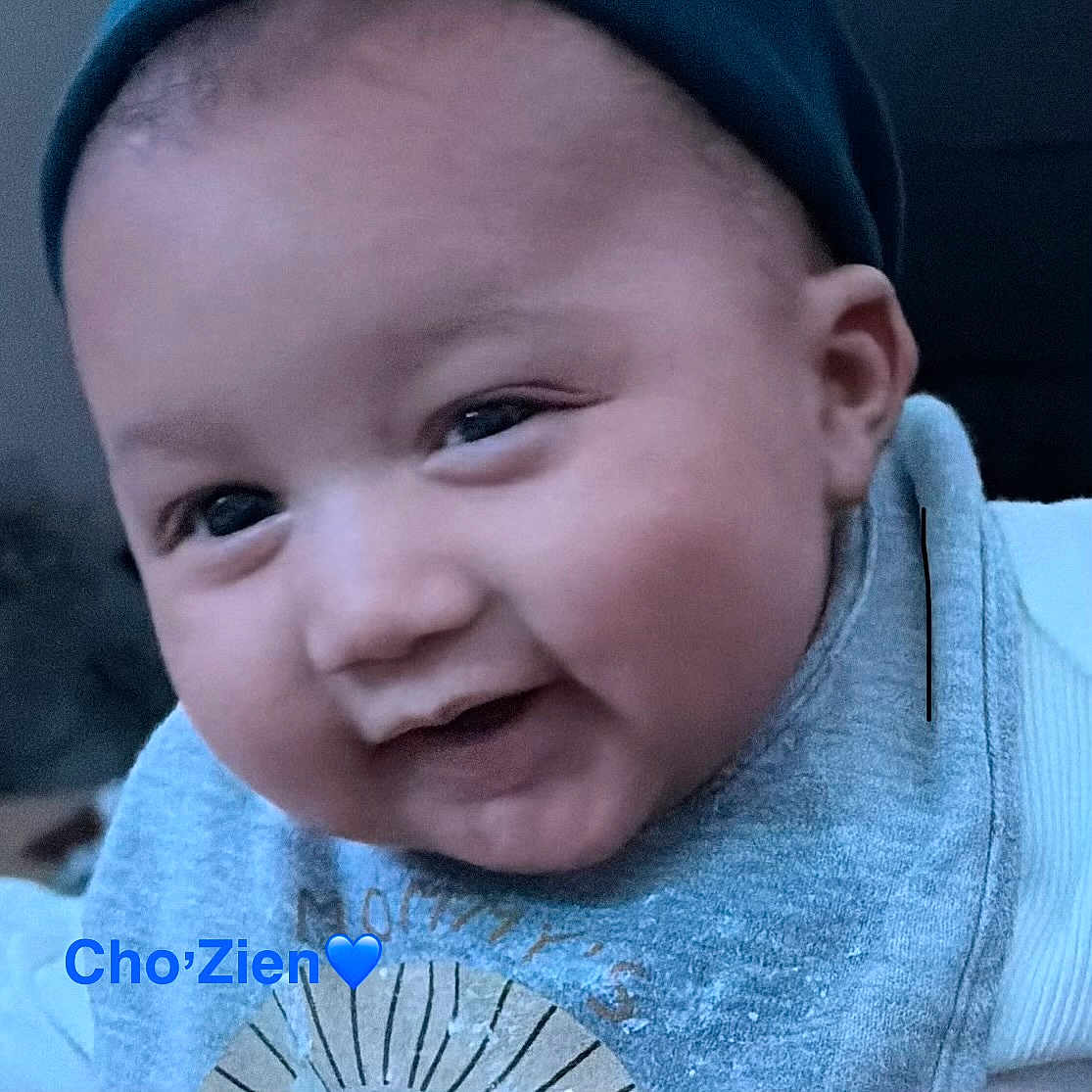 Chozien joined the competition — help win amazing prizes! baby, child, infant, portrait, close_up, face, eyes, serious_expression, gray_clothing, blue_clothing, head, cheeks, short_hair, sitting, indoor, soft_lighting, dark_background, photography, text_overlay, heart