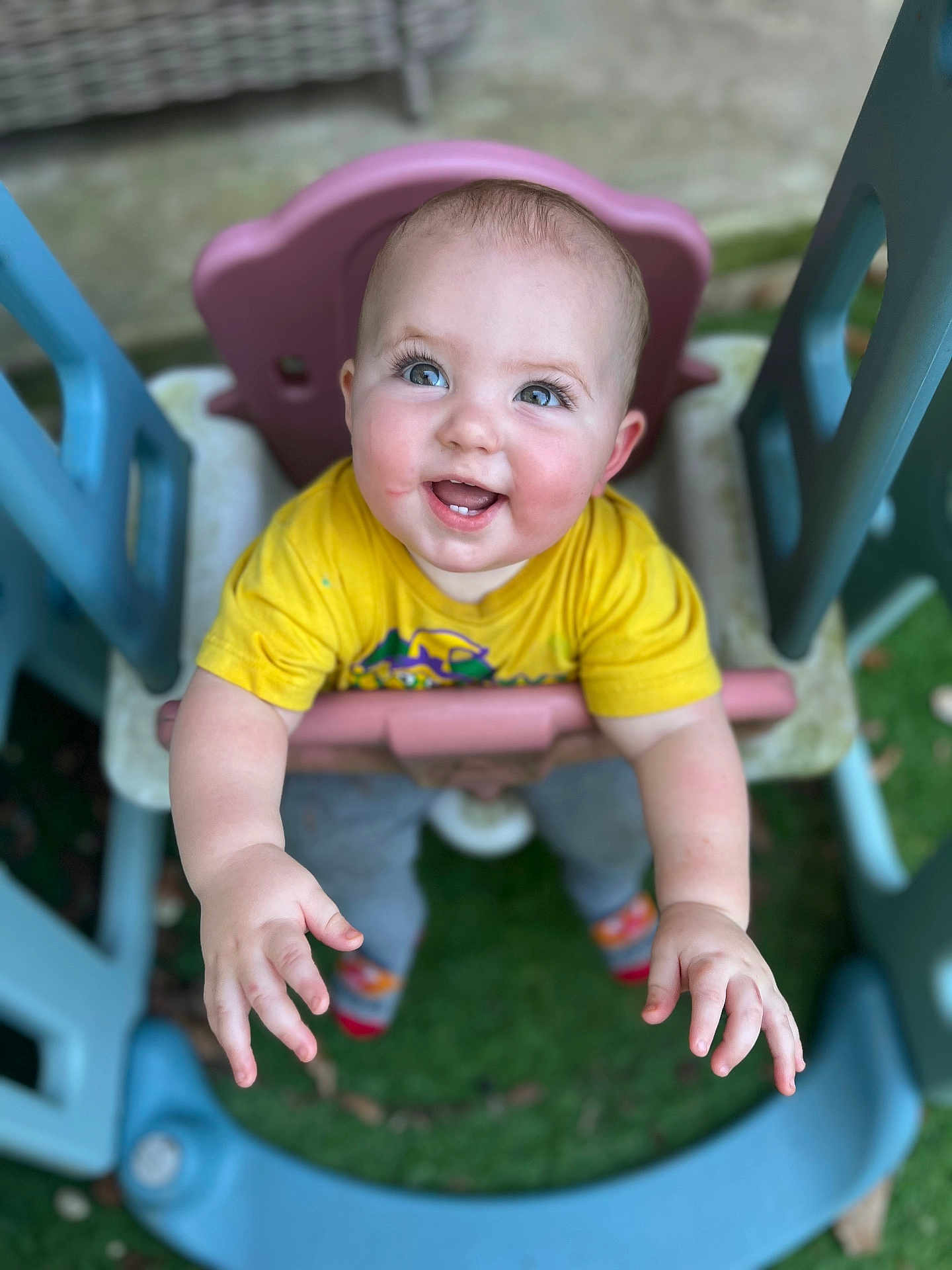 Asher joined the competition — help win amazing prizes! baby, child, swing, playground, outdoor, happy, smiling, yellow_shirt, blue_eyes, grass, plastic, toy, play, cute, infant, hands, feet, casual_clothing, daylight, fun