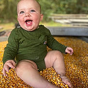 Asher joined the competition — help win amazing prizes! baby, blurred_background, casual_wear, cheerful, child, closeup, corn, corn_kernels, cute, foot, green_clothing, hand, happy, infant, nature, outdoor, playful, sitting, skin, smiling
