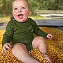 baby, child, corn, corn_kernels, green_clothing, outdoor, nature, happy, smiling, sitting, skin, foot, hand, blurred_background, infant, casual_wear, cheerful, closeup, cute, playful