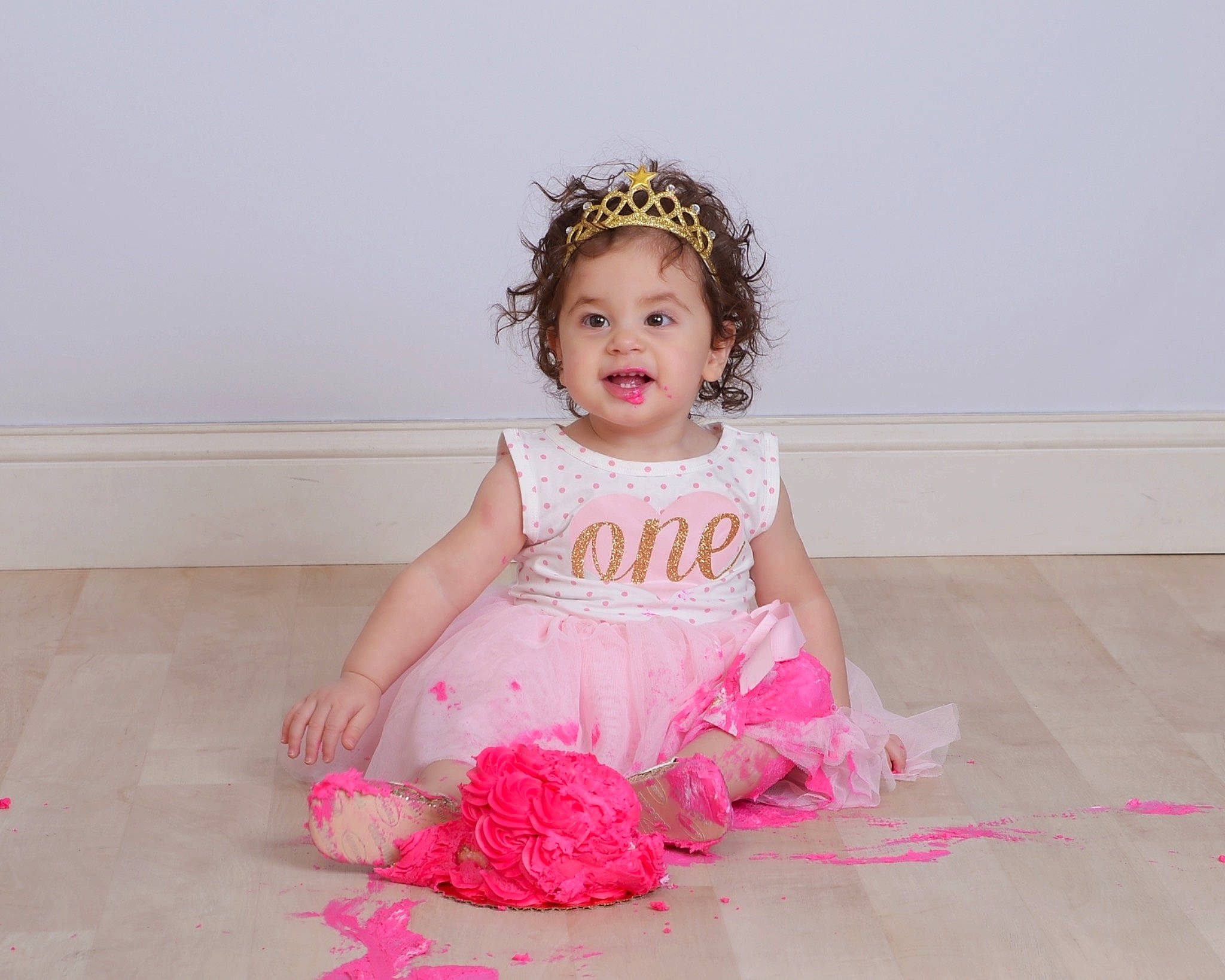 Meilani is registered to the contest to win money with this photo: baby, baby_toddler_clothing, child, child_model, crown, day_dress, dress, embellishment, floor, flooring, hair_accessory, headband, headgear, headpiece, mouth, person, pink, ruffle, tiara, toddler