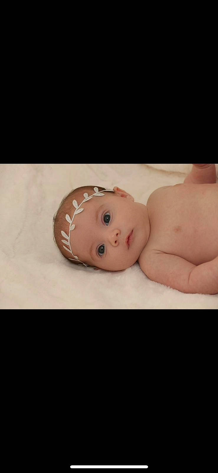 Lila is registered to the contest to win money with this photo: baby, baby_products, baby_toddler_clothing, cheek, chest, child, comfort, flesh, happy, headwear, linens, person, portrait_photography, room, sitting, skin, sleeve, smile, stomach, toddler