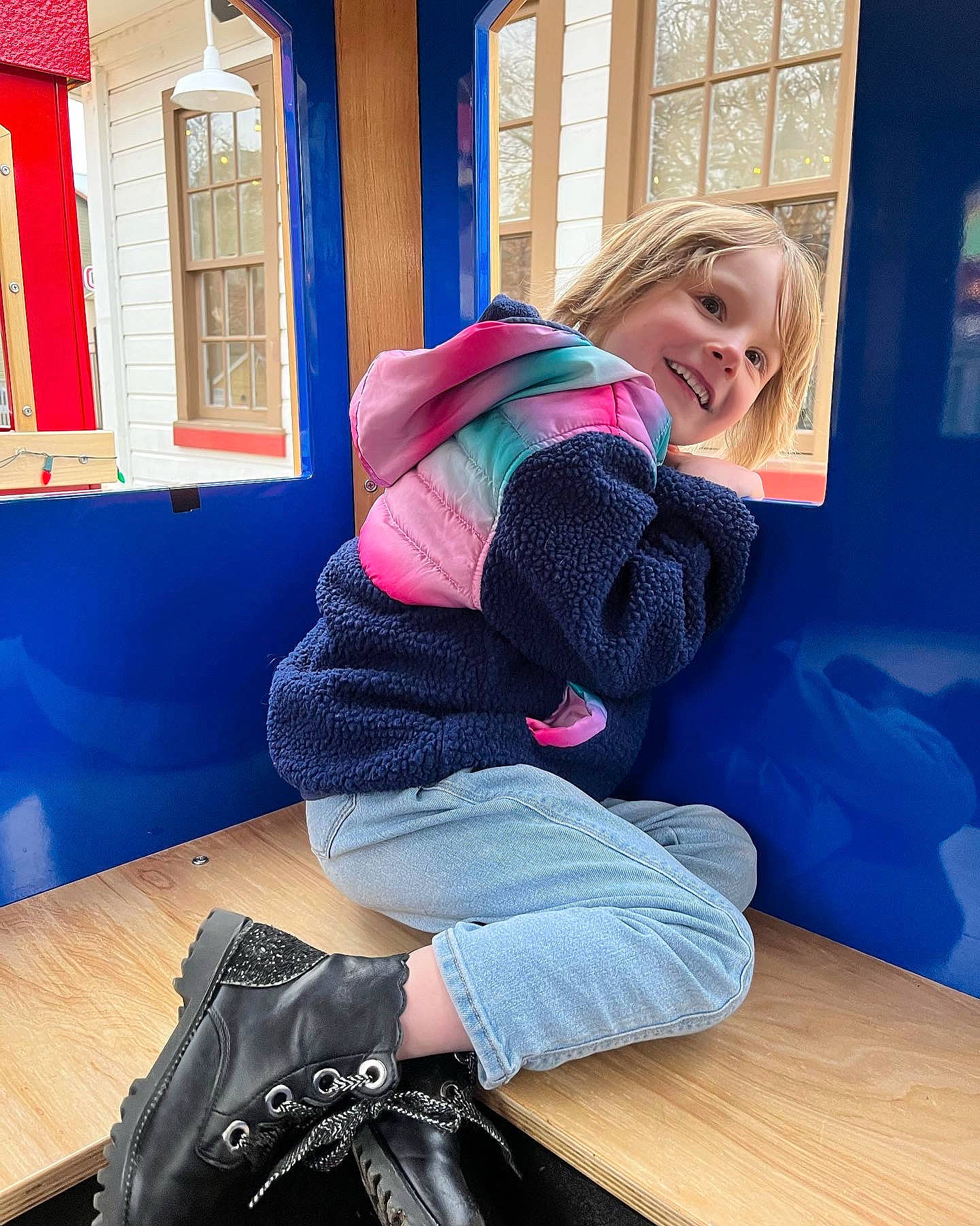 Faye is registered to the contest to win money with this photo: blue, comfort, denim, electric_blue, flooring, fun, human_leg, joy, knee, leisure, luggage_and_bags, magenta, person, room, sitting, smile, sportswear, table, thigh, travel