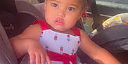 Rayanna is registered to the contest to win money with this photo: toddler, child, car_seat, sippy_cup, dress, blue_bow, sunlight, car_interior, window, seatbelt, face, person, cute, indoors, vehicle, sitting, young_child, summer, bright, expression