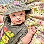 Elizabeth joined the competition — help win amazing prizes! baby, infant, hat, bucket_hat, face, blue_eyes, hand, clothing, shirt, pattern, blanket, floral, cute, portrait, lying_down, skin, child, expression, indoor, apparel