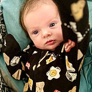 Elizabeth is registered to the contest to win money with this photo: baby, infant, onesie, clothing, face, eyes, hand, blanket, bed, sleepwear, cute, child, expression, portrait, newborn, fabric, pattern, comfort, indoor, soft