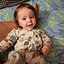 Kenneth joined the competition — help win amazing prizes! baby, child, infant, onesie, animal_print, blanket, dinosaur_pattern, polka_dot_pillow, smiling, happy, kicking, lying_down, cute, indoors, soft_texture, furniture, person, head, face, hand