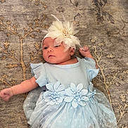 Vanessa joined the competition — help win amazing prizes! baby, infant, blue_dress, flower_headband, carpet, pattern, cute, lying_down, child, soft_fabric, indoors, peaceful, small_hands, small_feet, adorable, portrait, floor, delicate, resting, curious