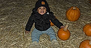 Onnyx is registered to the contest to win money with this photo: toddler, child, pumpkin, straw, hat, jacket, boots, outdoor, autumn, fall, smile, beanie, seasonal, harvest, festival, nature, person, sitting, cute, night