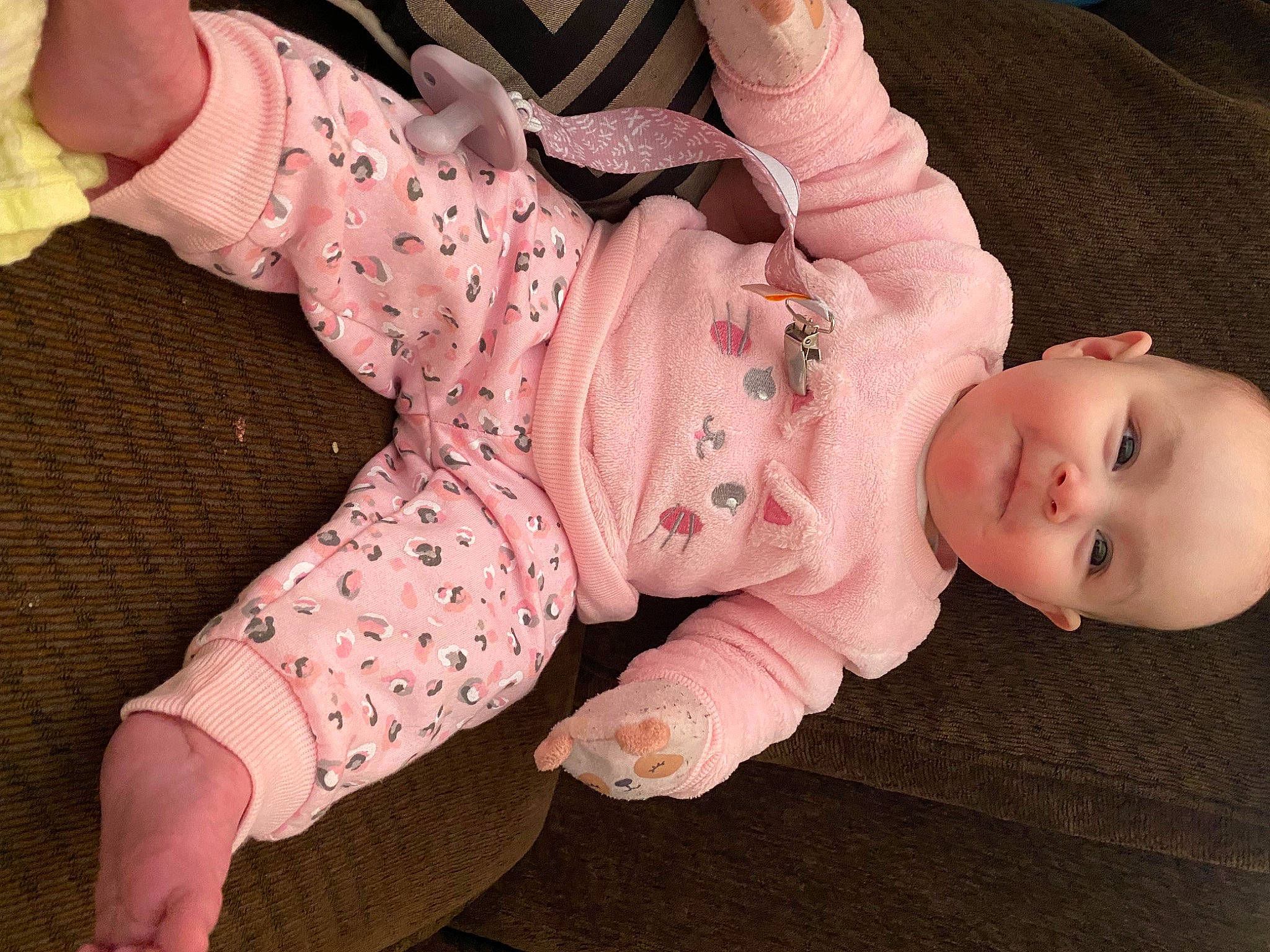 Alani is registered to the contest to win money with this photo: baby, baby_products, baby_sleeping, baby_toddler_clothing, cheek, comfort, eye, face, finger, foot, head, human_body, nail, pattern, person, pink, sitting, sleeve, sock, thumb