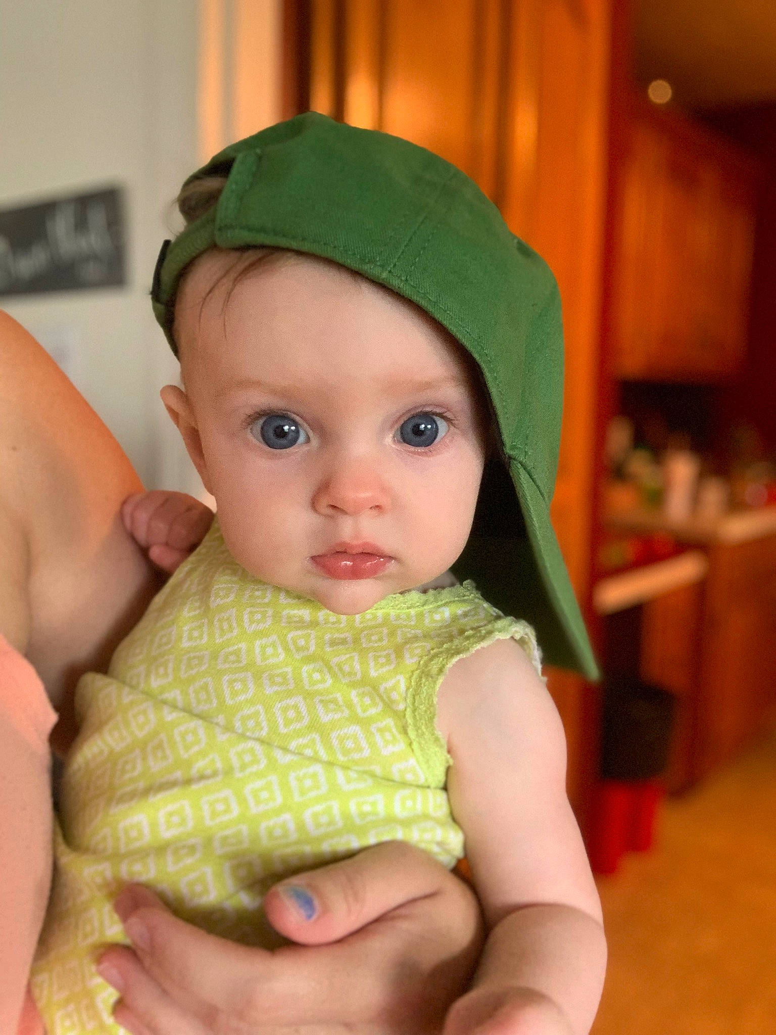 Jacklyn is registered to the contest to win money with this photo: baby, baby_products, baby_toddler_clothing, cap, cheek, child, chin, costume_hat, eye, fashion_accessory, gesture, green, headwear, lip, nail, pattern, peach, person, sitting, skin
