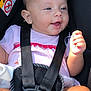 baby, infant, car_seat, seat_belt, harness, buckle, red_button, smile, hand, pacifier_ring, pink_clothing, ear, face, eyes, mouth, skin, closeup, portrait, sunlight, seat