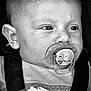 baby, infant, pacifier, car_seat, child, closeup, face, ear, eyes, nose, mouth, seat_strap, clothing, black_and_white, portrait, expression, chin, cheek, tiny_hands, reflection