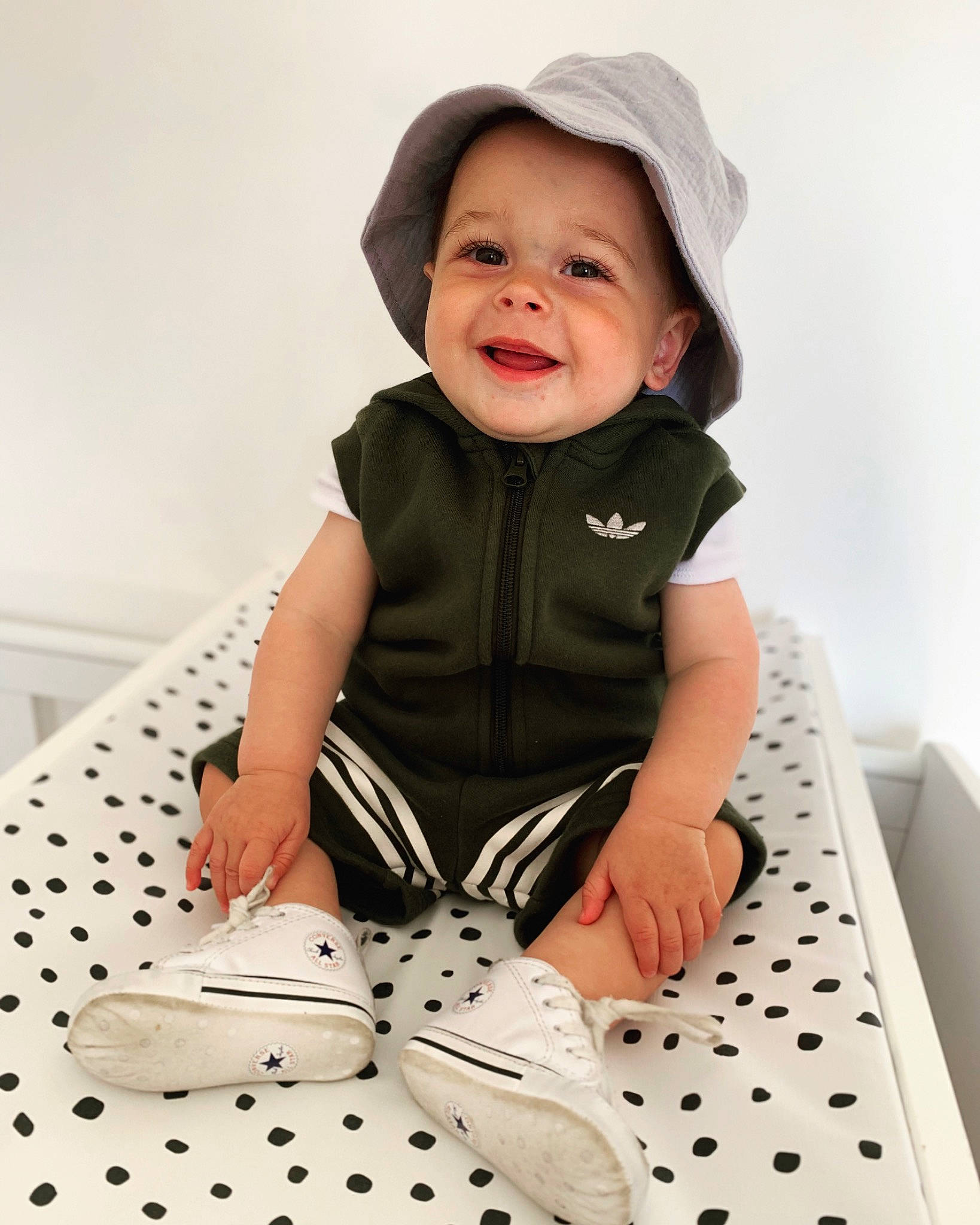 Albert is registered to the contest to win money with this photo: baby, baby_toddler_clothing, black, cap, child, collar, dress, face, facial_expression, fashion_accessory, happy, outerwear, pattern, person, sitting, sleeve, smile, street_fashion, t_shirt, toddler