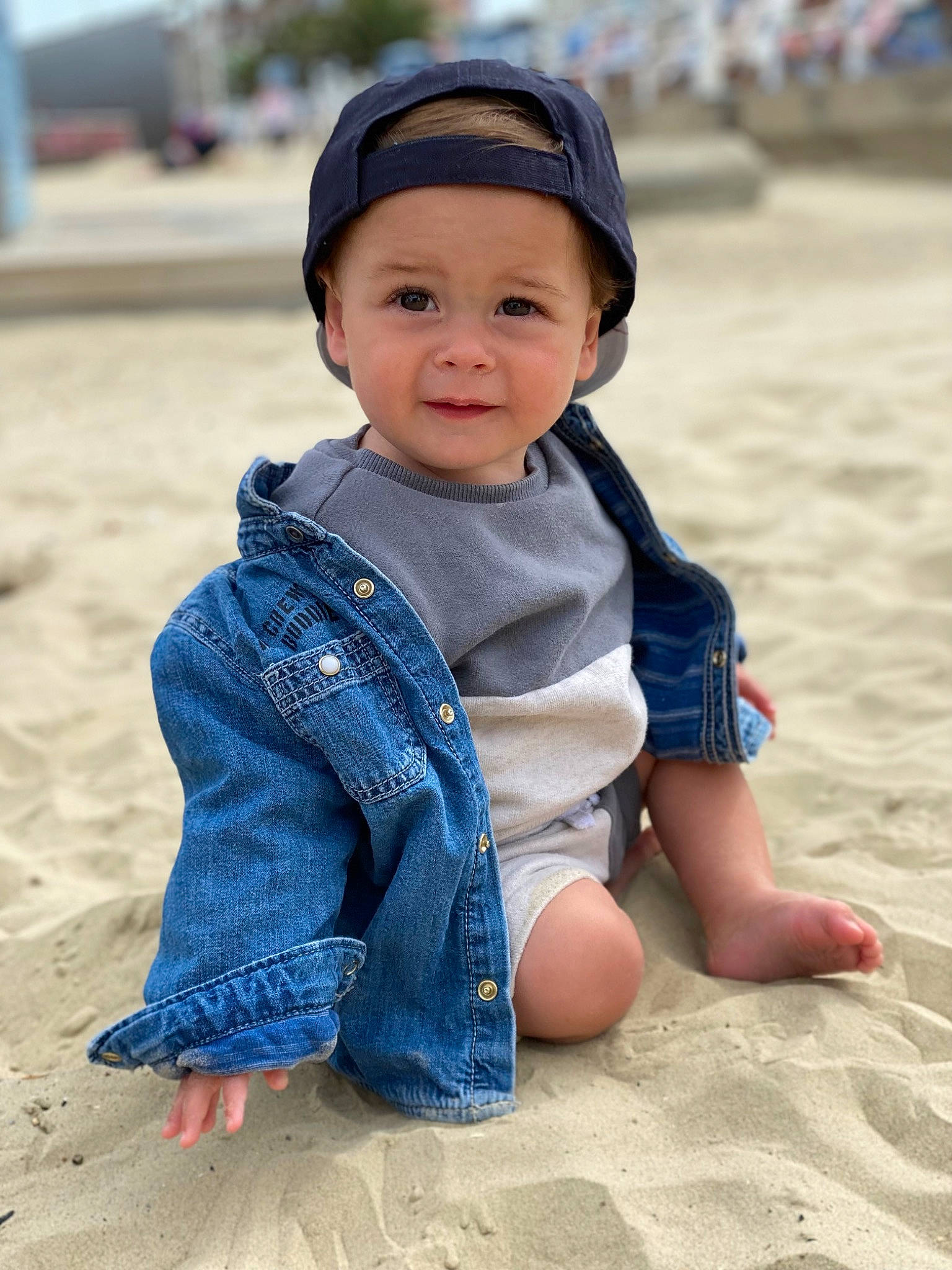 Albert is registered to the contest to win money with this photo: azure, baby_toddler_clothing, barefoot, beach, cap, child, electric_blue, fun, happy, headwear, landscape, leisure, person, personal_protective_equipment, sand, sitting, sleeve, smile, soil, standing