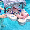 baby, pool, water, float, sunhat, infant, swimming_pool, child, floating_device, blue, safety_harness, summer, outdoor, relaxing, person, hands, sunshade, cute, infant_clothing, feet