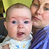 Savannah is registered to the contest to win money with this photo: baby, woman, indoor, holding, face, expression, clothing, person, portrait, child, smile, blue_eyes, short_sleeves, home, clock, wall, casual, parent, family, love