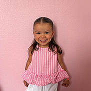 Lila participe au concours pour gagner de l'argent avec cette photo : child, girl, smiling, happy, pink_wall, pink_top, white_shorts, bracelet, dimples, portrait, standing, indoor, cute, fashion, hair, young, childhood, person, casual, colorful