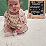 Eleanor is registered to the contest to win money with this photo: 2026, 5_months, baby, blanket, bow, cute, floral_onesie, green_backdrop, indoor, infant, letter_board, milestone_board, name_embroidery, pink, portrait, quilt, sitting, socks, tongue_out, wooden_easel