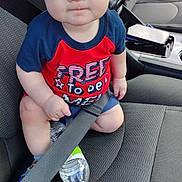 Tristan is registered to the contest to win money with this photo: baby, child, car_seat, seatbelt, water_bottle, blue_eyes, red_shirt, shorts, car_interior, seat, sitting, clothing, person, infant, cute, portrait, vehicle, safety, expression, indoors