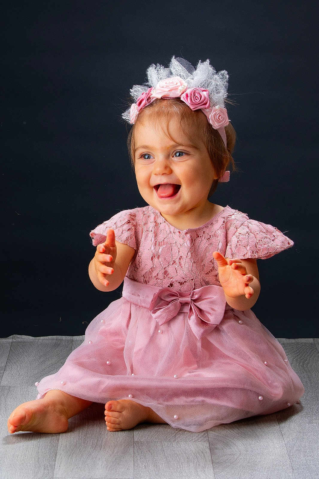 Alix a rejoint le concours — aidez-le/la à gagner de superbes lots ! toddler, child, smiling, pink_dress, headband, flowers, barefoot, sitting, happy, portrait, studio, floor, lace, bow, young_child, cute, hands, blue_eyes, indoor, baby
