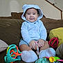 baby, child, hoodie, blue_clothing, smile, toy, couch, indoor, infant, cute, socks, playtime, happy, person, young_child, soft_toys, seated, home, comfort, casual