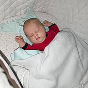 émyjio a rejoint le concours — aidez-le/la à gagner de superbes lots ! baby, sleeping, blanket, crib, infant, red_clothing, white_blanket, star_pattern, quilted, peaceful, face, head, hands, pale_skin, soft_lighting, indoor, child, resting, cozy, toddler