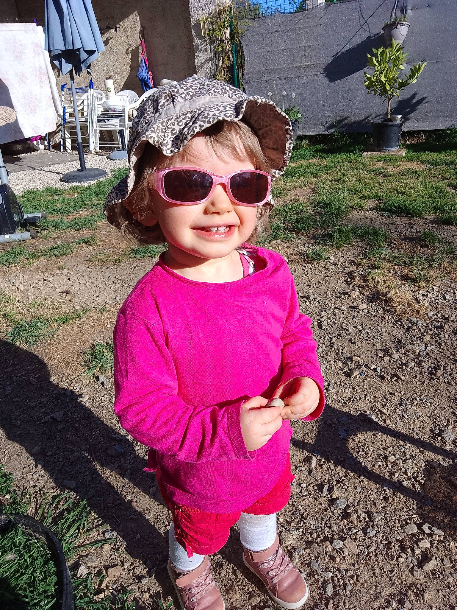 Meredith participe au concours pour gagner de l'argent avec cette photo : baby_toddler_clothing, botany, eyewear, goggles, grass, green, happy, joy, leaf, leisure, morning, people, people_in_nature, person, pink, plant, sleeve, summer, sunglasses, toddler