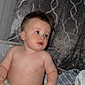 Ace is registered to the contest to win money with this photo: baby, child, shirtless, pajamas, dinosaur_pattern, blanket, bed, curly_hair, indoor, cozy, soft_texture, cute, toddler, sleepwear, resting, portrait, infant, furniture, relaxed, expression