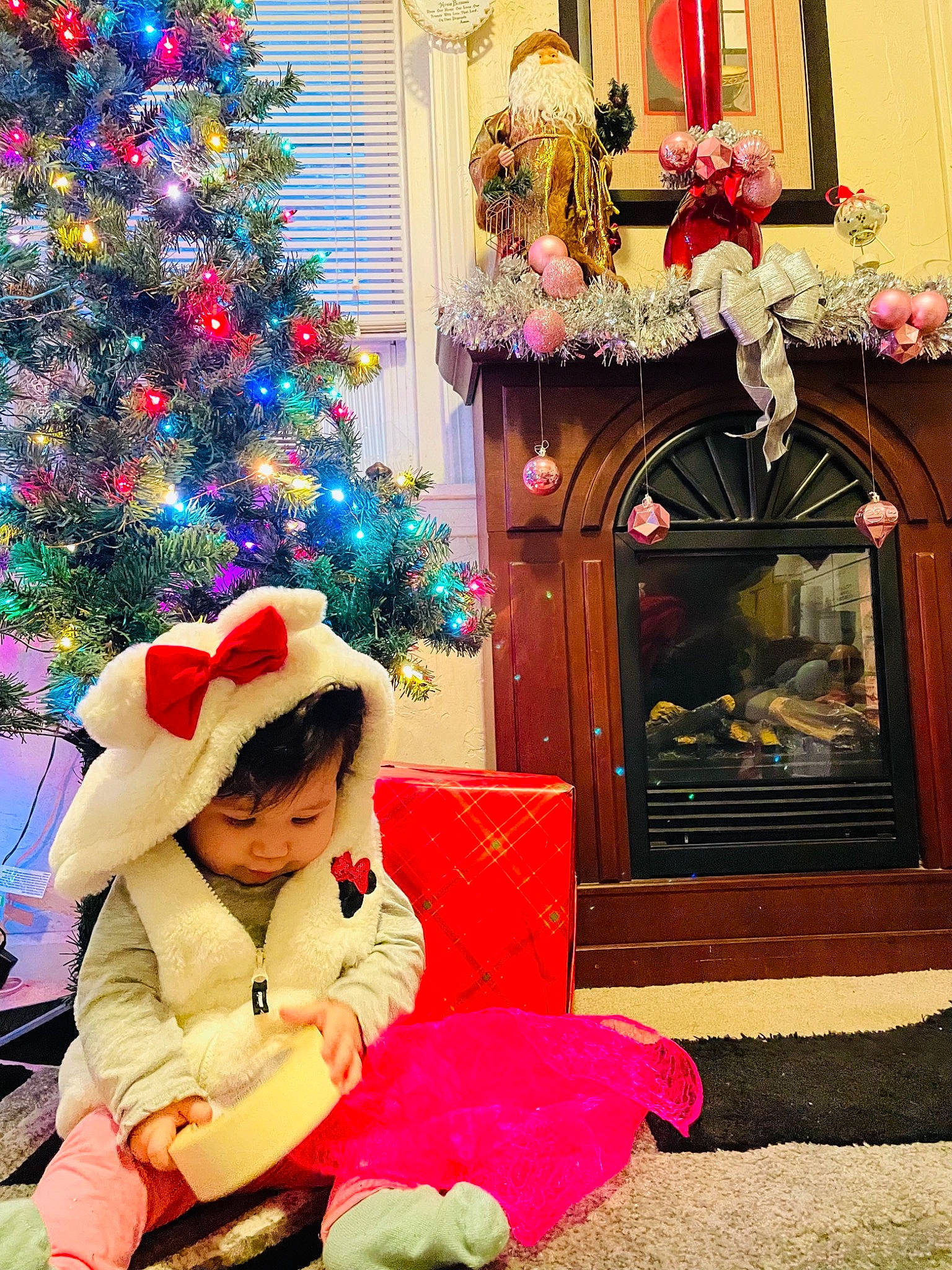 Guadalupe is registered to the contest to win money with this photo: christmas, christmas_decoration, christmas_ornament, christmas_tree, decoration, event, green, happy, hat, holiday, holiday_ornament, lap, ornament, person, pink, red, snapshot, toddler, tradition, tree