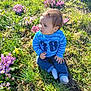 Solan a rejoint le concours — aidez-le/la à gagner de superbes lots ! baby, blue_shirt, casual_clothing, child, curious, cute, daylight, flowers, grass, greenery, jeans, nature, outdoor, portrait, purple_flowers, sitting, sunlight, toddler, yellow_flower, young_child