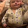 baby, sleeping, onesie, paw_print, blanket, cozy, infant, hand, closed_eyes, smile, bedroom, pillow, soft_lighting, cute, child, indoor, peaceful, cute_outfit, sleep, toddler